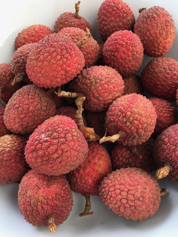 A bowl of unpeeled litchis